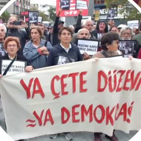 Kalabalık bir grup “Ya çete düzeni ya demokrasi” yazılı pankartı taşıyor.